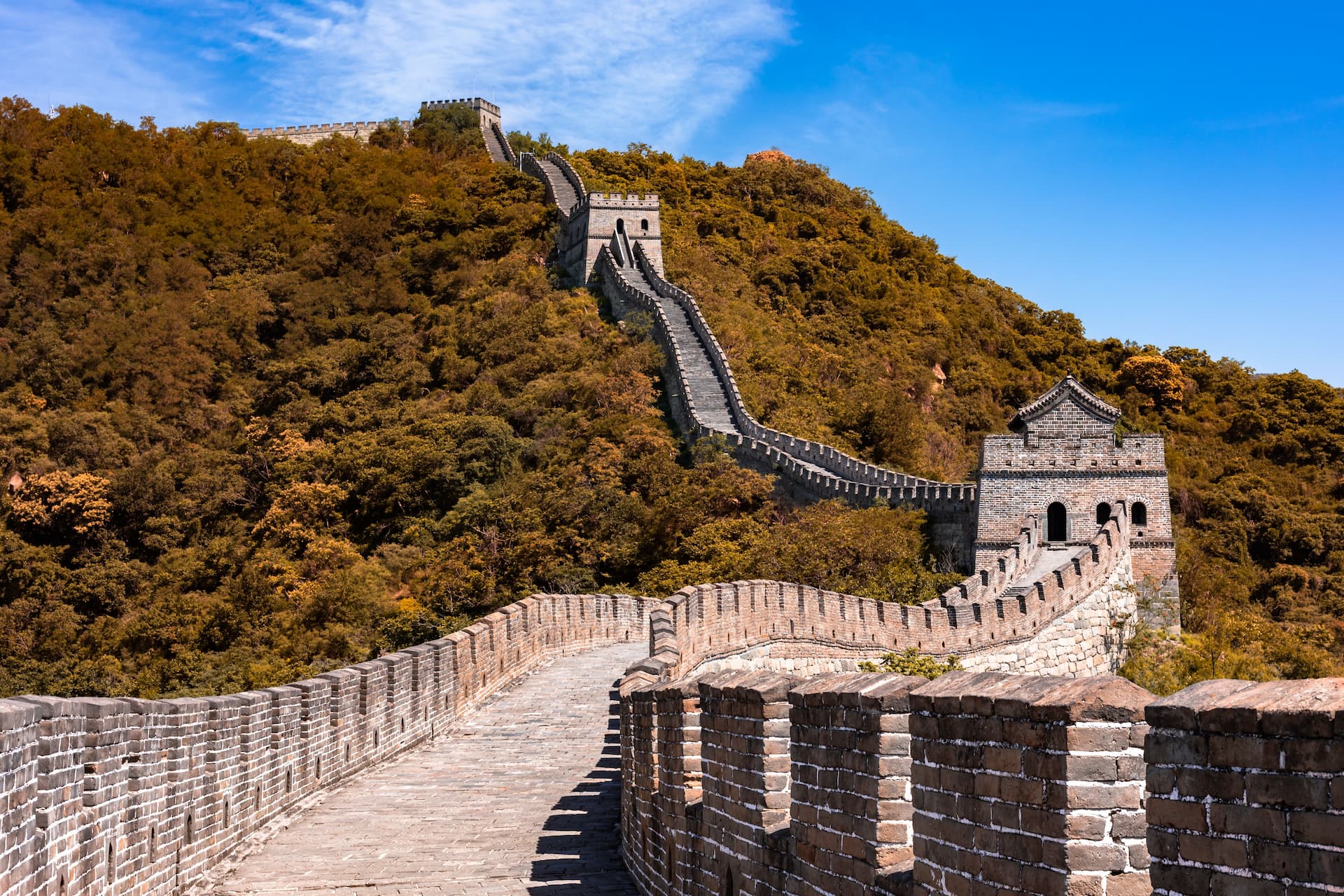 The Great Wall of China winding over green mountains